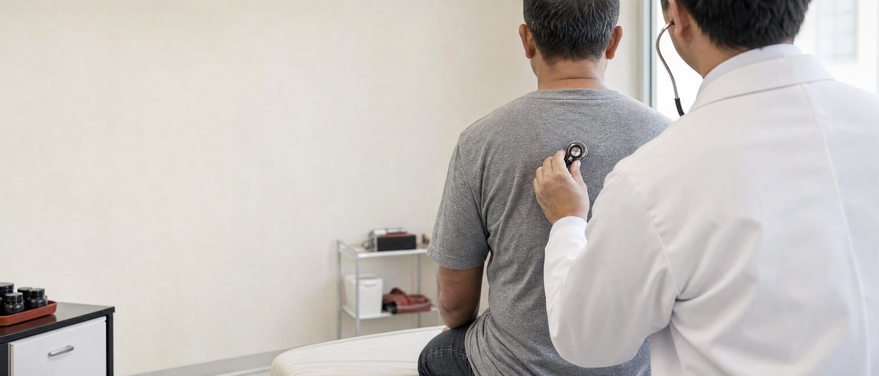 A doctor listens to a worker's lungs, the first check for silica exposure symptoms